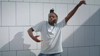 Sokak dansı yapan etkileyici bir dansçı. Kahverengi tenli adam sahnede modern dans provası yapıyor. Dışarıya bakan sanatçı çocuk. Duvar arkasında Afrikalı Amerikalı sanatçı eğitimi
