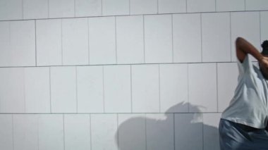 Plastik adam sokak çekimlerinde dans provası yapıyor. Beton duvar arka planında çağdaş şehvetli hareketler yapan Afrikalı Amerikalı dansçı. Açık alanda gizli dans eğitimi veren yetenekli bir adam.