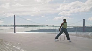 Esnek adam seti tek başına eğitiyor. Afrikalı Amerikalı adam okyanus manzaralı bir yerde çağdaş bale gösterisi yapıyor. Sahilde prova dansının keyfini çıkaran etkileyici bir sanatçı. Doğaçlama konsept 