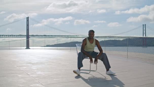 Moderne Danser Zit Stoel Zee Achtergrond Afro Amerikaanse Man Zoek — Stockvideo