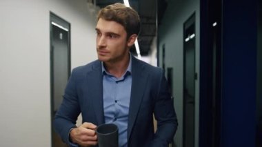 Elinde kahve fincanı tutan rahat bir çalışan. Şirketin CEO 'su yemek saatinde dinleniyor. Kendine güvenen yakışıklı müdür iş yerinden ayrılan aromanın tadını çıkarıyor. Şirket yaşam tarzı kavramı.