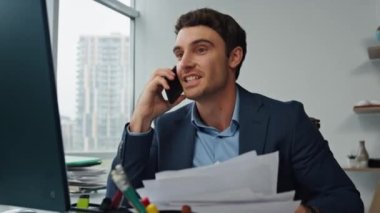 Ofiste cep telefonuyla konuşan mutlu girişimci. Başarılı müvekkil sözleşmesini kutlayan neşeli bir menajer. Akıllı telefonu kullanarak gülümseyen işadamı zaferi ortağıyla paylaşıyor..