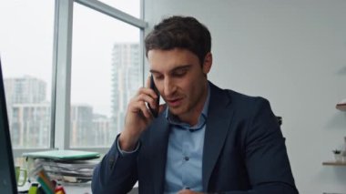 Ofiste cep telefonuyla konuşan neşeli bir yönetici. Çağdaş iş yerinde mutlu bir iş adamı işi bitiriyor. Yakışıklı girişimci partneriyle başarılı sonuçlar paylaşır. Proje zafer kavramı