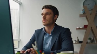 Çağdaş ofiste çalışan yakışıklı bir iş adamı bilgisayarı. Odaklanmış finansal profesyonel görünümlü ekranlı internet. Dijital pazarlama çalışanı çevrimiçi iş arkadaşıyla sohbet ediyor.