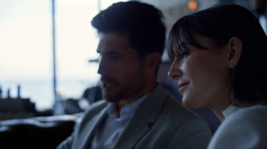 Man woman watching discussing in dusk office closeup. Colleagues brainstorming in hotel restaurant lounge. Smart confident businesswoman presenting ideas to creative partner inside dark hall