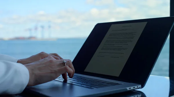 Businesswoman hands typing laptop contract in office closeup. Unknown expert using computer checking documents at panoramic window place. Unrecognizable manager correcting report invoice at hotel