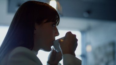 Kadın yüz dinlenme espresso yakın çekim. Rahat iş kadını silueti, koyu kafede kahve molası veriyor. İsimsiz bir lider lüks otel salonunda sıcak bir içecek yudumluyor. Tatil kavramı