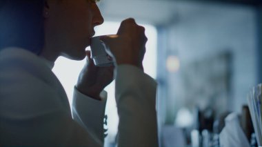 İş kadını elleri kahve fincanını yakın çekimde tutuyor. Rahat kadın silueti, Dark Cafe 'de içkinin tadını çıkarıyor. Tanımlanamayan bir çalışan restoranda sıcak espresso tadıyor. İş molası konseptinde yönetici 