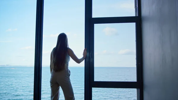 Lonely woman thinking problems at panorama window. Upset businesswoman crying making decision at sea rear view. Depressed ceo financial manager silhouette rest in office. Emotional breakdown concept