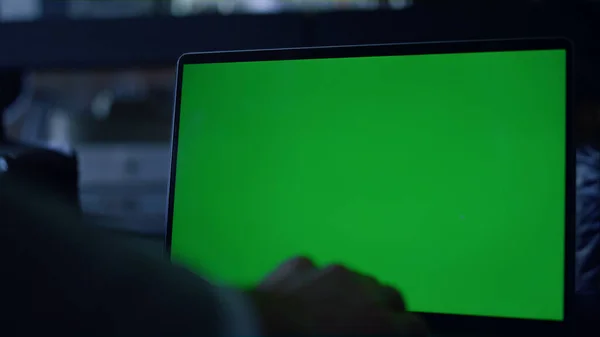Closeup businessman typing chroma key computer at dark workplace. Unrecognized professional man writing business email green screen laptop in office. Unknown executive browsing internet mockup device