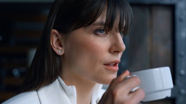 Yakın plan kahve içen ciddi bir kadın. Lüks otel portresinde dinlenen düşünceli bir iş kadını. Lider, mesafeye bakıyor ve gelecek kararlarını veriyor. Lider tek başına tatilin tadını çıkarıyor. 