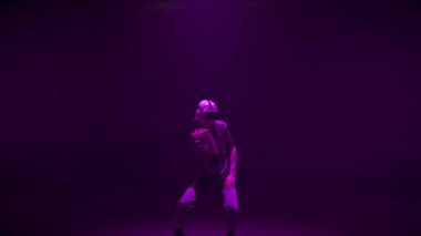 Sanal gerçeklik hipster 'ı neon ışıklarda dans ediyor. Metaverse oynatıcı kulaklıkta simülasyon yaşıyor. Oyundan zevk alan tanınmamış enerjik oyuncu. Futuristik artırılmış oyun performansı.