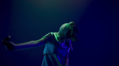 Spellbound girl using vr glasses closeup. Virtual reality headset woman watching movie playing videogame slow motion. Amazed gamer person taking new experience future technologies neon light 