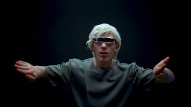 Fütürist gözlüklerle artırılmış gerçeklik oynayan etkileyici bir adam. Siber adam yüksek teknoloji aygıtına metaevren simülasyonunu daldırdı. Çevrimiçi dünyaya adım atan heyecanlı sarışın oyuncu. Gelecekteki eğlence teknolojisi.