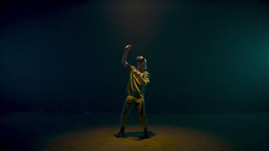 Millennial playing vr game in dark neon cyberspace. Man experiencing augmented reality simulation in vibrant lights. Unrecognized excited gamer enjoying interacting metaverse. Smart innovation concept