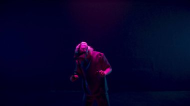 Neon siber uzayda VR oyununun tadını çıkaran bir adam. Oyuncu konsol simülasyonunu fütüristik kulaklıkla yaşıyor. Bilinmeyen oyuncu, artan gerçekliği araştırıyor. Siber hafta sonu eğlence konsepti.