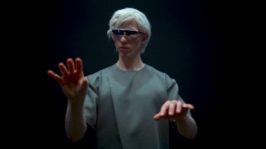 Sanal gerçeklik gözlüklerini yazan siber adam. Metaverse adam artırılmış simülasyonda internette sohbet ediyor. Geleceğin mühendisi yüksek teknoloji kulaklıkla kodlama yapıyor. Karanlık odada el kol hareketi yapan gelecekçi mühendis. 