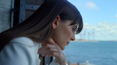 Deniz manzaralı toplantı odasında dizüstü bilgisayarın başarılı olduğunu düşünüyor. Şirket yöneticisi çevrimiçi proje raporlarını kontrol ediyor. Panoramik ofiste iş yanıtını hazırlayan lider 