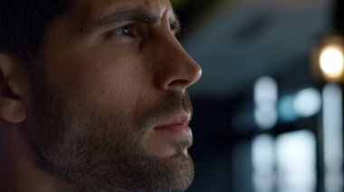 Karizmatik bir adam, kafeterya profilinde vakit geçiriyor. Düşünceli bir iş adamı, karanlık otel barına bakıyor. Erkek yüz ifadesini yakından inceliyorum. Ciddi karar konsepti.