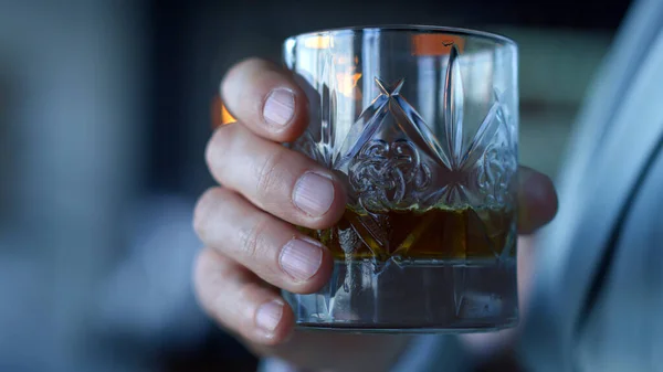 Businessman hands drinking whiskey in restaurant closeup. Unrecognizable gentleman tasting beverage in luxury hotel room. Ceo relaxing enjoying alcohol in office. Unknown man burbon glass concept