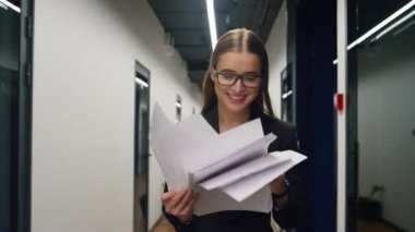 Neşeli yönetici koridordaki belgeleri kontrol ediyor. Müşteri toplantısından sonra mutlu bir satış temsilcisi gibi görün. Gülümseyen iş kadını başarı projelerinin sonuçlarının keyfini çıkarıyor. Heyecanlı ofis stajyeri iş buldu.