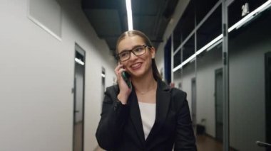 Mutlu yönetici konuşması cep telefonu. Başarılı iş kadını koridorda yürürken iş arkadaşlarıyla proje paylaşımı yapıyor. Gülümseyen işçi ofisi terk ediyor. Heyecanlı çalışan iş tanıtım müvekkil sözleşmesi aldı