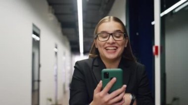 İş kadını, yakın plan telefon kullanarak sanal görüşme yapıyor. Mutlu yönetici, şirketin olumlu sonuçlarını paylaşma projesinin tadını çıkarıyor. Güzel, gülümseyen bir kadın..