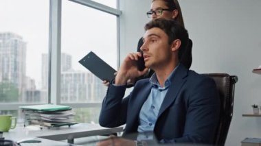 Şirket yöneticisi ofiste telefonla konuşuyor. Güzel asistan kontrat belgelerini getiriyor. Başarılı CEO pazarlama patronu iş sorunlarını görüşmek için kağıtları imzalıyor. Şirket yöneticisi kavramı