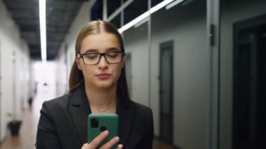 Sanal konferansta portre yöneticisi konuşuyor. Endişeli kadın cam koridorda yürürken kameradan iş ortağını arıyor. Sinirli iş kadını banka asistanı sakin ol. Müşteriyle telefonda konuş.