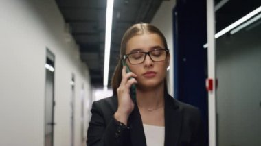 Ofiste telefonla konuşan yakın plan iş kadını. Satış müdürü müşteriyi çağdaş koridorda yürümeye çağırıyor. Düşünceli uzman kadın iş merkezindeki işi tartışıyor. Finans işçisi kariyer kavramı