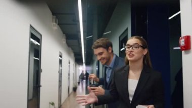 Dost canlısı iş arkadaşları sabah ofiste yürüyorlar. İki yönetici ellerinde kahve fincanları tutarak hafta sonundan sonra fikirleri paylaşıyorlar. Başarılı iş ekibi pazarlama projesini tartışıyor. Kurumsal yaşam tarzı.