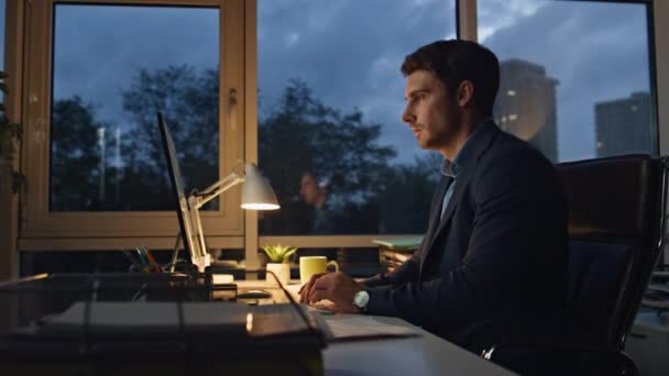 疲れた男の仕事のオフィスだけで遅い 会社の経営者は職場での休憩を取る目の緊張を被る 夜間にコンピュータを入力して報告するフリーランスのエグゼクティブに焦点を当てました ストレスの多い従業員 — ストック動画
