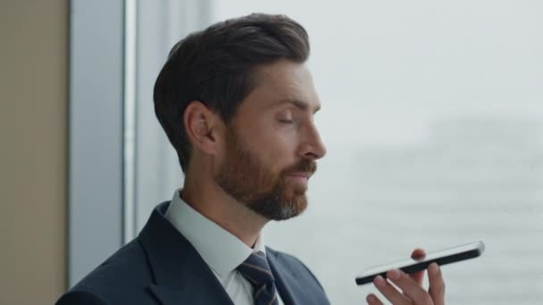 Сосредоточенный Бородатый Бизнесмен Заканчивает Телефонный Разговор Стоя Окна Офиса Задумчивый — стоковое видео