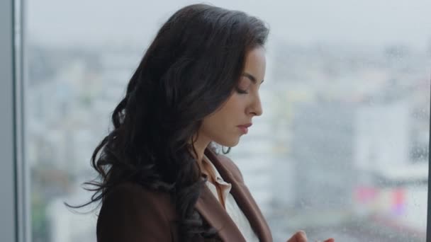 Atrakcyjna Młoda Kobieta Biznesu Przewijając Smartfon Stojąc Przy Oknie Panoramicznym — Wideo stockowe