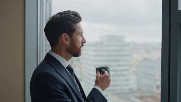 사려깊은 사업가 사무실의 파노라마 창문턱에서 커피를 마시는 이보입니다 수염을 관리자의 — 비디오