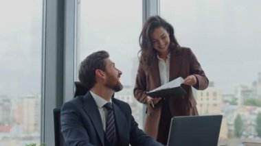 Şirketimizin lüks ofisinde çekici sekreterle çalışan sırıtan sakallı bir iş adamı. Kendine güvenen CEO, dizüstü bilgisayar kullanarak masa başında oturuyor. İş belgelerini tutan mutlu esmer kadın asistan..