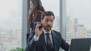 Meşgul ortaklar modern ofiste iş başarısızlığı projesini tartışıyorlar. Esmer iş kadını telefonda hoşnutsuz bir şekilde konuşurken yönetici masasında dizüstü bilgisayar yazıyor. Stresli ekip çalışıyor.