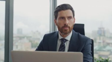 Sakallı CEO, not defterine iş notları yazıyor. Lüks ofis masasına yakın çekim yapıyor. Belgelerde çalışan kendinden emin orta yaşlı bir iş adamı. Düşünceli yönetici yeni şirket stratejisi düşünüyor..