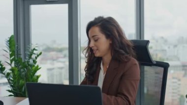 Modern ofis kamerasıyla internet üzerinden danışmanlık yapan profesyonel bir kadın yönetici. Pozitif gülümseyen iş kadını iş arkadaşlarıyla uzaktan iş görüşmeleri yapıyor.