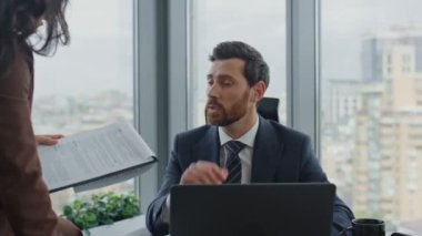 Zeki iş arkadaşları iş hakkında konuşuyor modern ofiste birlikte oturarak beyin fırtınası yapıyorlar. Kendine güvenen iş adamları iş projesini tartışıyor, belgeleri okuyor. Başarılı ortaklık kavramı