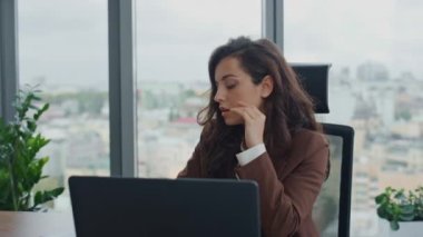 Çok çalışan çekici kadın ofis yöneticisi modern dizüstü bilgisayarla masa başında oturuyor. Kendine güvenen iş kadını CEO 'su iş kararları üzerinde kafa yoruyor sorunları çözüyordu..