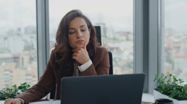 Odaklanamayan iş kadını laptopuyla lüks bir ofiste masa başında oturuyor. Motivasyonsuz bayan girişimci bilgisayar ekranında yorgun hissediyor. Şirket kabinesinde iş sorunları olduğunu düşünmek yorucu..
