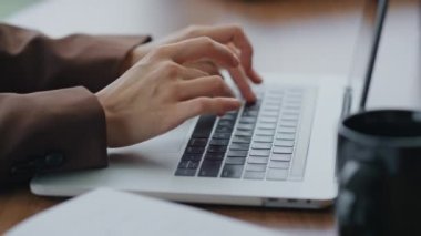 Kadın elleri dizüstü bilgisayarda yazı yazıyor. Ahşap masaya yakın duruyor. Modern bilgisayarda çalışan, e-posta yazan, internette arama yapan tanınmamış bir iş kadını. Not defteri kullanan genç bir kız..