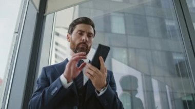 Stresli iş adamı, panoramik pencerenin yanında kötü bir telefon konuşmasını sonlandırıyor. Endişeli proje yöneticisi akıllı telefon konuşmasını içeride bitirdi. Seçkin CEO ofis işinden dolayı umutsuzluğa düştü.