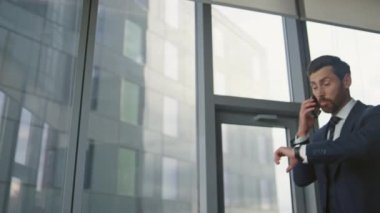 Ofis penceresinde cep telefonuyla duygusal konuşmalar yapan gergin bir CEO. Saldırgan iş adamı cep telefonuyla şirket sorunlarını tartışıyor. Stresli girişimci kapalı alanda akıllı telefon jestleriyle tartışıyor.