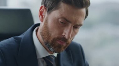 Zarif bir takım elbiseyle çalışan sakallı bir adamın portresi. Düşünceli iş adamı kârlı yatırım şirketlerinin bakış açılarını düşünüyor. CEO yöneticisi düşünme stratejisini kapatıyor.