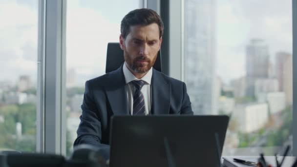 ラップトップを使用して現代のオフィスで働く集中型髭ビジネスマンの肖像画 モニターのクローズアップを見てコンピュータキーボードを入力し 深刻な魅力的なマネージャー 会社の問題を解決する熟練労働者 — ストック動画