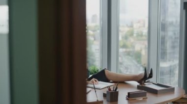Neşeli kadın patron telefonda konuşuyor, bacakları masaya koyuyor, modern ofiste panoramik pencereli oturuyor. Kendine güvenen esmer CEO 'lar akıllı telefon kullanarak güzel sohbetler yaparlar. İş kadını ara veriyor.