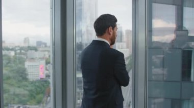 Endişeli adam ofis penceresinin yanındaki aramayı bitirdi. Düşünceli iş adamı kötü haber duyma stresi yaşıyor. Çekici sakallı yönetici şirket sorunlarını düşünüyor. İş konsepti
