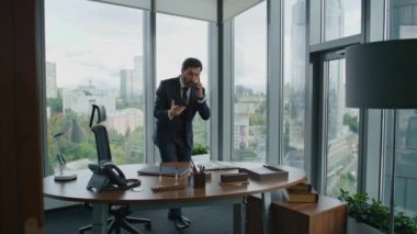 Kızgın işadamı, modern ofiste bekleyen telefon görüşmesini bitirdi. Orta yaşlı sinirli girişimci akıllı telefondan bağırıyor. Tatmin olmayan iş adamı iş başarısızlığına duygusal tepki veriyor. Şirket krizi.